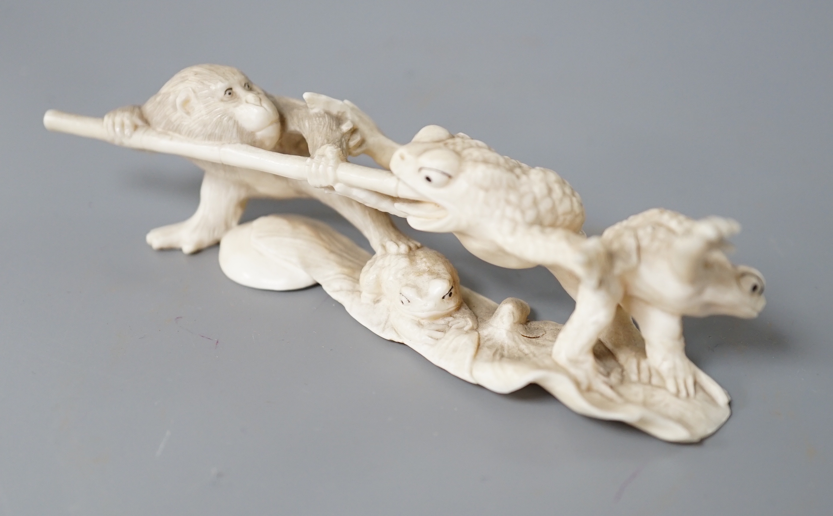A Japanese ivory okimono of a monkey and toads, Meiji period, 12cm